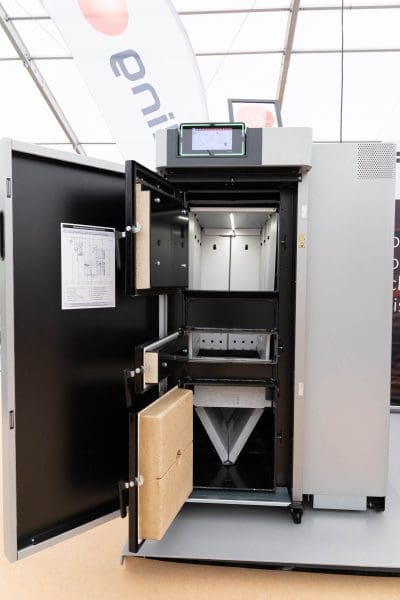 Große Industriemaschine mit geöffneter Fronttür, die mehrere Fächer und ein an der Innenseite der Tür angebrachtes Diagramm offenbart. Auf der Oberseite der Maschine befindet sich ein digitaler Anzeigebildschirm.