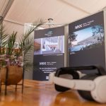 Auf einem Tisch vor zwei Informationstafeln über die Messe | Kongress | Kulturforum in Saarbrücken steht ein VR-Headset; außerdem sind Pflanzen und eine kleine Topfpflanze zu sehen.